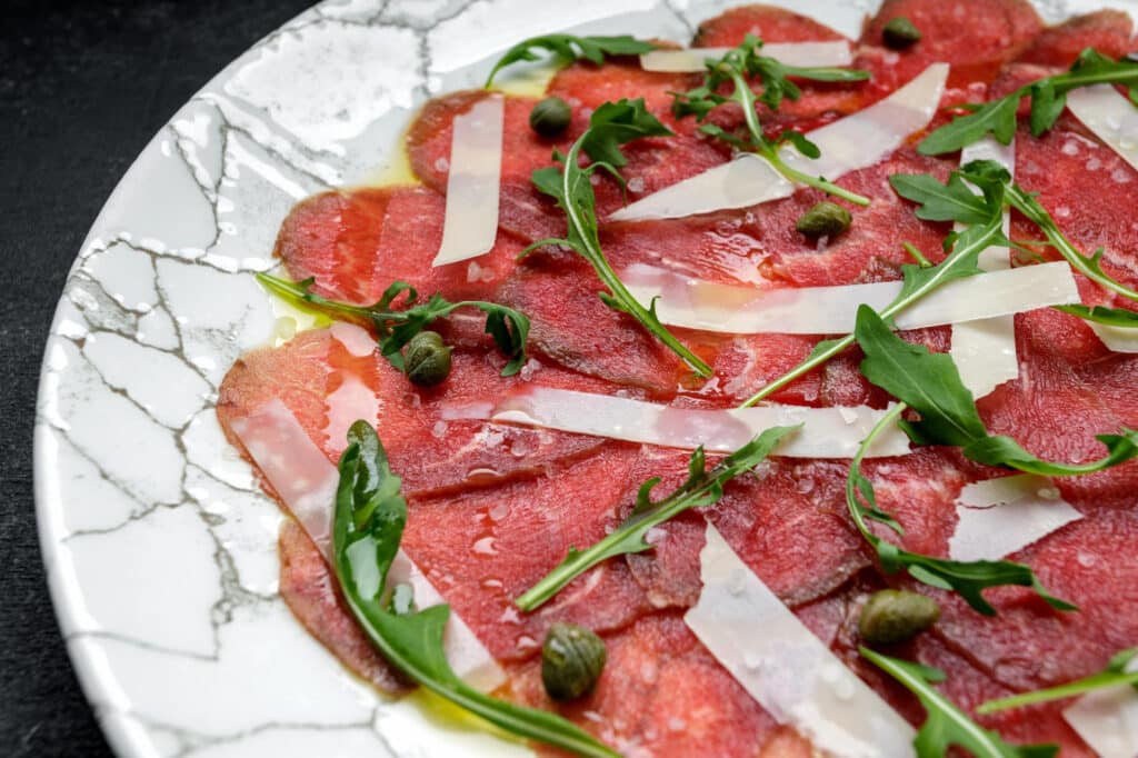 Carpaccio de bœuf servi dans une assiette.